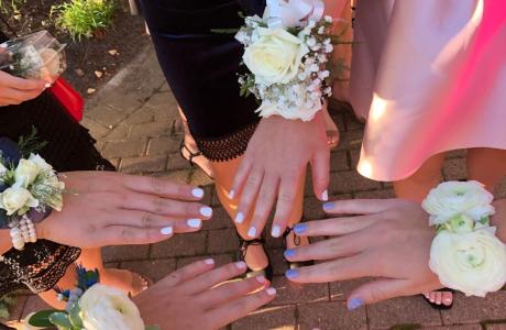 Image of student hands with white corsages