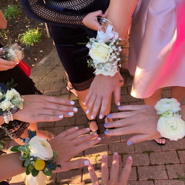 Image of student hands with white corsages