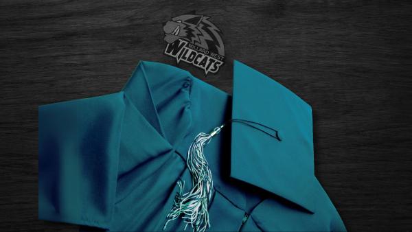 Green graduation cap and gown and a wildcat logo laying on a black wood surface