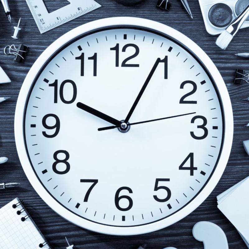 Image of clock surrounded by school supplies