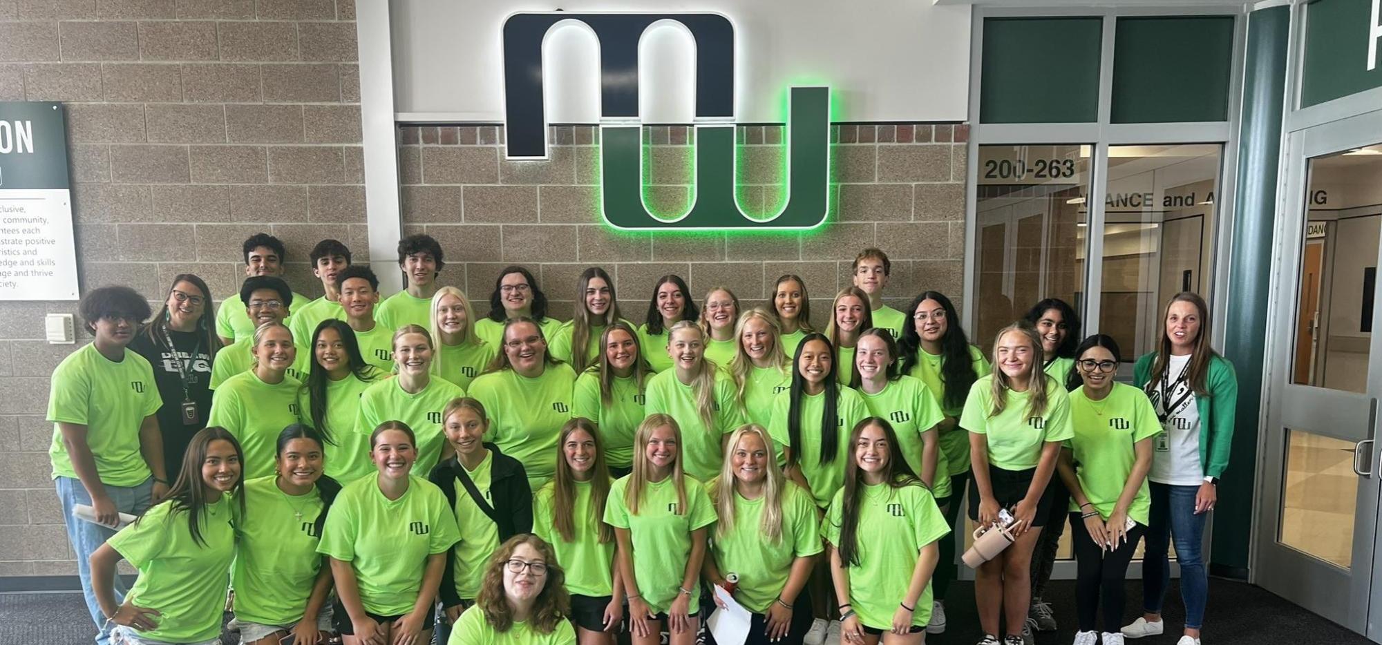 Image of Student Leaders in Cat Crew shirts posing under the Millard West Logo